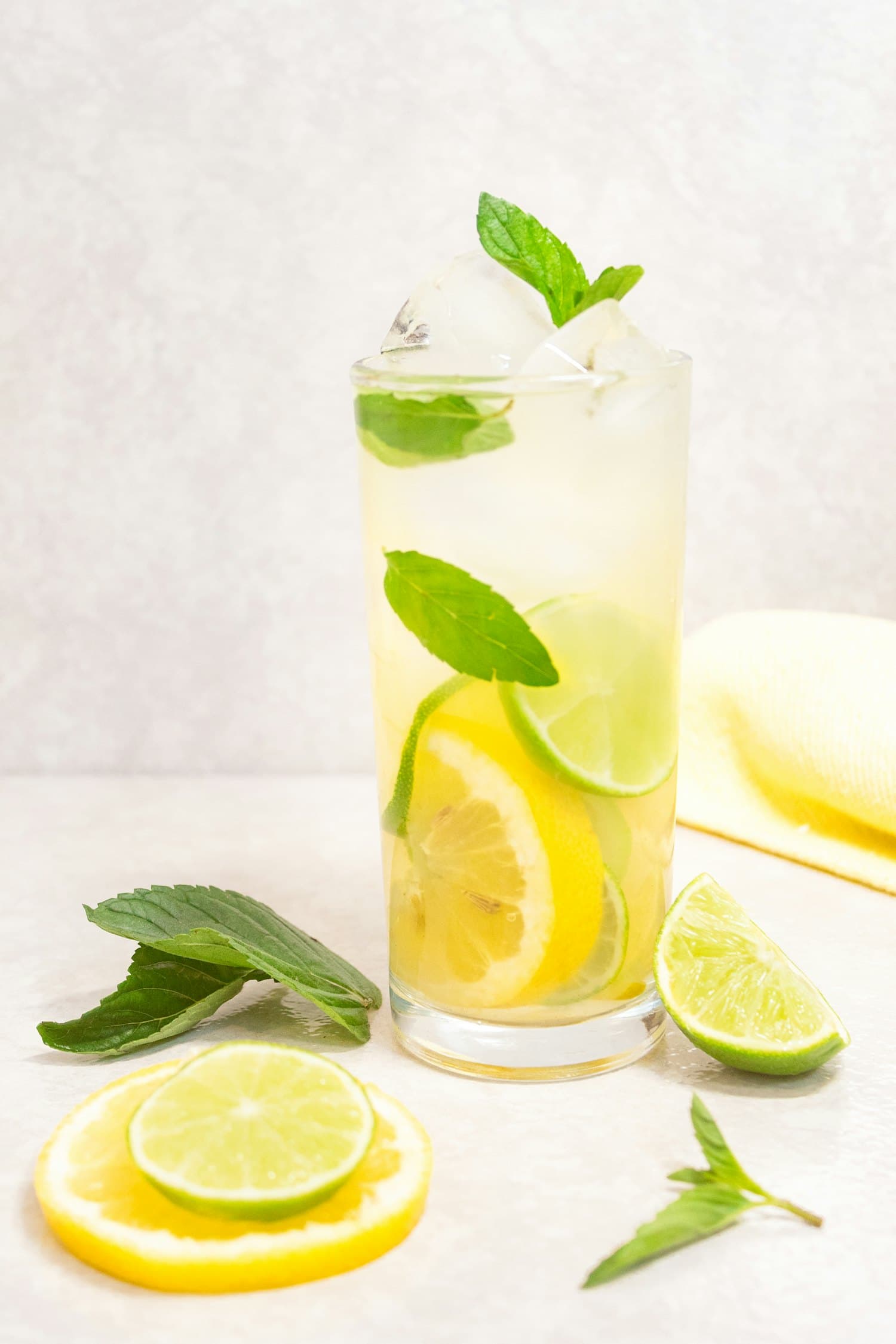 A tall glass of cloudy lemonade with mint