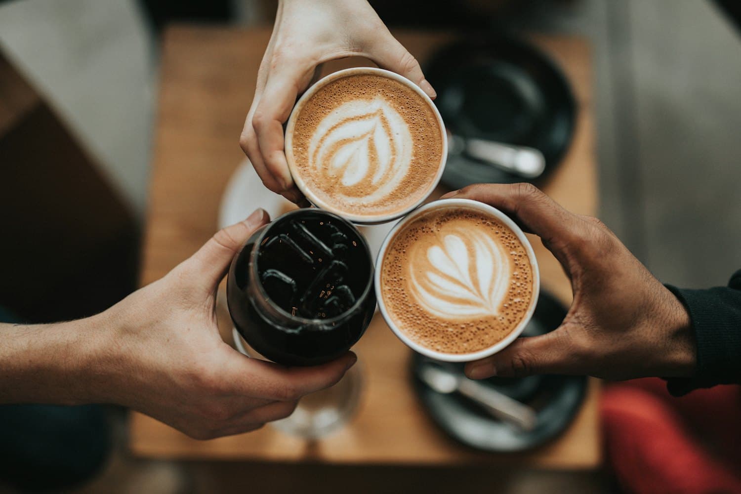 Two coffees with latte art on a cafe table