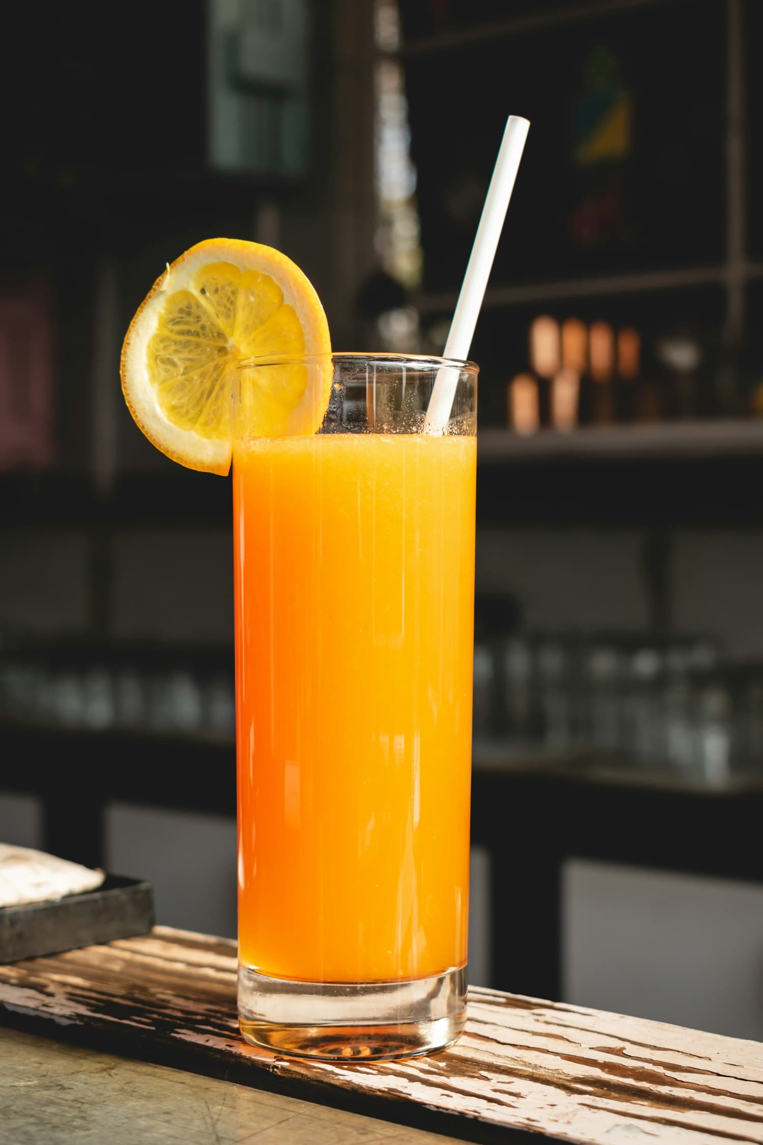 A tall glass of fresh juice with a citrus wheel