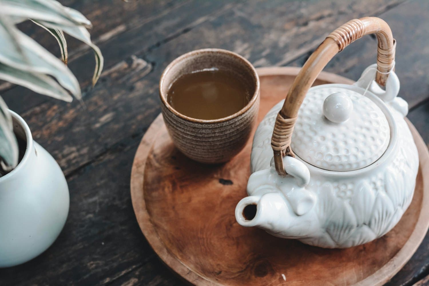 A cup of tea beside biscuits in soft morning light
